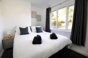 Un dormitorio con una cama con dos sombreros negros. en Beautiful Home in West Midlands, 