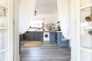 eine Küche mit blauen Schränken und einer Waschmaschine und einem Trockner in der Unterkunft Paradiso Vintage Villa: Traditional 1944 Gem in Amanioú + 64 Fotos