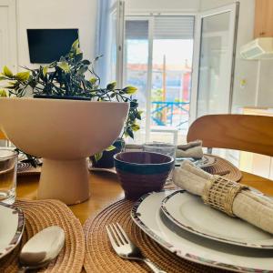 una mesa con platos y un tazón y una planta en Central Apartments Ariadni, en Ofrinion
