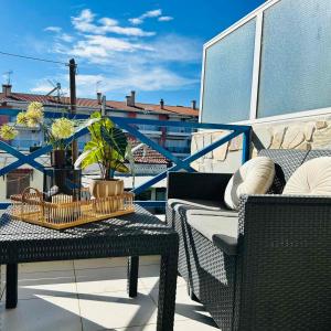 - Balcón con mesa y 2 sillas de mimbre en Central Apartments Ariadni, en Ofrinion