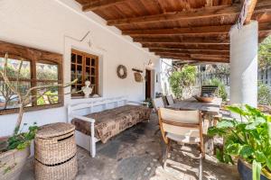 ein Schlafzimmer mit einem Bett und einem Tisch auf einer Terrasse in der Unterkunft Paradiso Vintage Villa: Traditional 1944 Gem in Amanioú