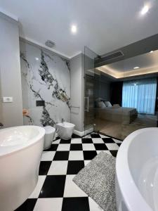 La salle de bains est pourvue de 2 lavabos, de 2 toilettes et d'une douche. dans l'établissement CLB Sea view Apartment, à Constanţa