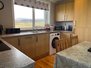 a kitchen with a sink and a washing machine at Buaile nan Carn in Kilmuir