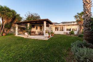 ein Haus mit einer Terrasse und einem Hof in der Unterkunft Paradiso Vintage Villa: Traditional 1944 Gem in Amanioú