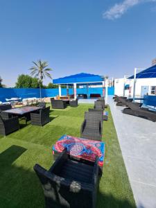 a patio with chairs and tables on the grass at Sharjah International Airport Hotel in Sharjah