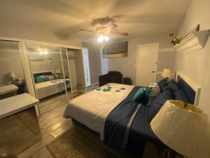 a bedroom with a large bed with a ceiling fan at Private Retreat in Lake Worth