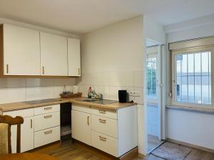 a kitchen with white cabinets and a sink and a window at Gemütliche Unterkunft in Baden-Baden direkt am Schwarzwald in Baden-Baden