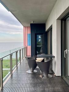 un balcon avec une table et des chaises donnant sur l'océan dans l'établissement CLB Sea view Apartment, à Constanţa