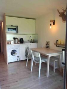 a kitchen with a table and chairs and a stove at La marmotte: Vue Mont Blanc, terrasse, parking in Combloux