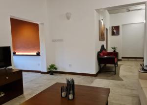 een woonkamer met een tafel en een stoel bij City Oasis 66 in Negombo