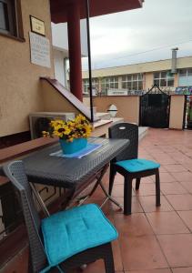 a table and chairs with a vase of flowers on it at Happiness Apartment Skopje in Skopje