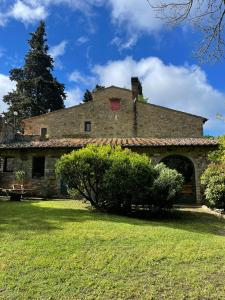 an old stone building with a tree in the background at Casa nel bosco Il Grottone in Montaione