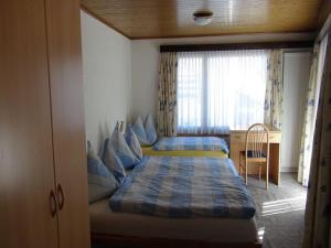 a small bedroom with a bed and a window at Pension Central in Saas-Almagell