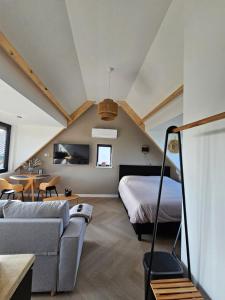 a bedroom with a bed and a couch in a room at Ybizee in Yerseke +48 photos