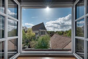 an open window with a view of a church at Le Splendide Collégiale Saint André in Chartres