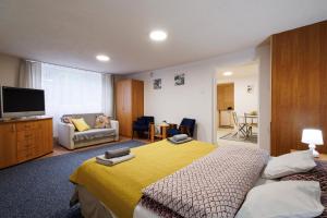 1 dormitorio con cama amarilla y sala de estar en Apartamenty przy Parku, en Łańcut