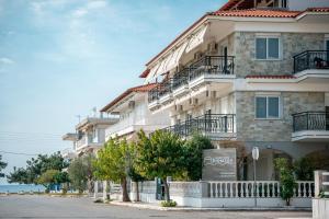 un edificio con una señal delante de él en Dionisos Apartments, en Paralia Dionisiou