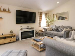 un soggiorno con divano e TV di Lakeland Dream a Warton