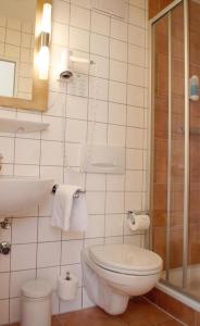 a white bathroom with a toilet and a sink at Hotel Am Obermarkt in Freiberg