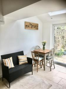 sala de estar con mesa, sillas y sofá en Bluebell Cottage, en Grassington