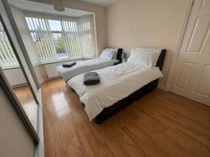 1 Schlafzimmer mit 2 Betten und einem Fenster in der Unterkunft Beautiful Home near Birmingham in Smethwick