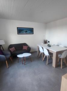 uma sala de estar com um sofá, uma mesa e cadeiras em Agréable Maison, toute équipée, proche du lac d'Arjuzanx em Morcenx
