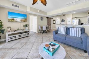 Una sala de estar con un sofá azul y una mesa. en Shores of Panama 1212, en Panama City Beach