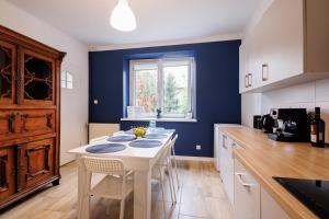 cocina con mesa blanca y pared azul en Apartamenty przy Parku, en Łańcut