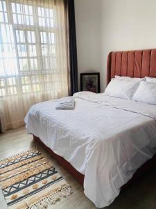 Schlafzimmer mit einem großen Bett mit einem roten Kopfteil in der Unterkunft Serenity Homes Arusha in Arusha