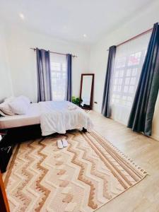 a bedroom with a bed and a rug on the floor at Serenity Homes Arusha in Arusha