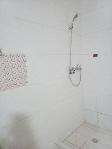 un bagno bianco con doccia e soffione di The Honey Moon a Santa Cruz de la Sierra