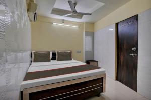 1 dormitorio con 1 cama grande y techo en Collection O Hotel Konark Inn, en Ahmedabad