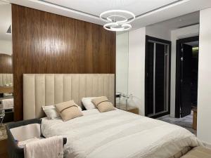 - une chambre avec un grand lit blanc dans l'établissement Appartement haut standing 3 min du parc prestigia, à Fès
