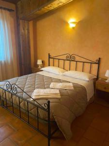 1 dormitorio con 1 cama grande con sábanas y almohadas blancas en Il Podere degli Asinelli, en Cappelle sul Tavo