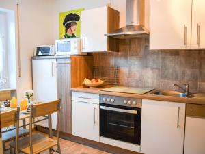 una cocina con armarios blancos y fregadero en Ferienwohnung Gaby Lehmann, en Hornberg