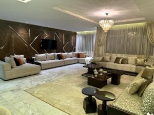 sala de estar amplia con sofás y TV en Appartement haut standing 3 min du parc prestigia, en Fez