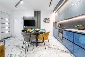 a kitchen with blue cabinets and a table and chairs at Sunset Premium Residence II & III in Dubrovnik