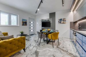 a kitchen and living room with a table and chairs at Sunset Premium Residence II & III in Dubrovnik