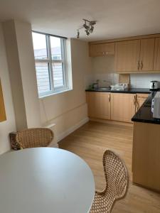 a kitchen with a table and chairs in a room at Macc Apartment in Macclesfield
