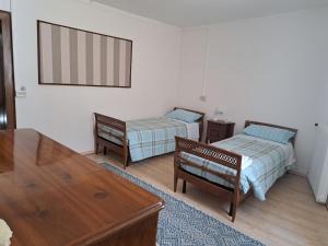 Sala de estar con 2 camas y mesa en La casa di Felice en San Vito al Tagliamento