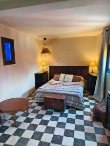 a bedroom with a bed and a checkered floor at Dar Nadia in El Jadida