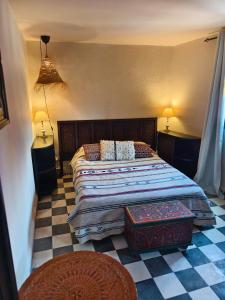 1 dormitorio con 1 cama y suelo a cuadros en Dar Nadia, en El Jadida