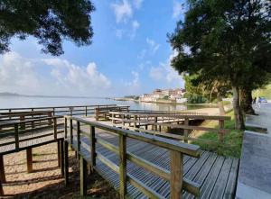 a row of benches sitting next to a body of water at Apartamento Barbanza Arousa in Boiro