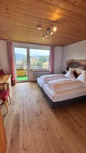 a large bedroom with two beds and a large window at Boutique Hotel and Apartments Pension Sternen in Todtmoos