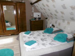um quarto com uma cama com almofadas azuis em Chambre Sologne em Saint-Julien-sur-Cher