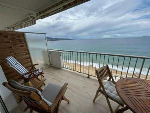 - un balcon avec des chaises, une table et la plage dans l'établissement Appartement Le Lavandou, 2 pièces, 4 personnes - FR-1-308-82, au Lavandou