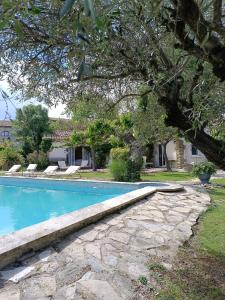 a swimming pool with a stone walkway next to a house at B&B Chambre indépendante double in Deaux