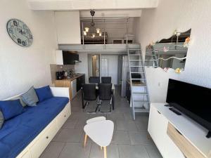 un soggiorno con divano blu e una cucina di Appartement Le Barcarès, 3 pièces, 6 personnes - FR-1-431-171 a Le Barcarès