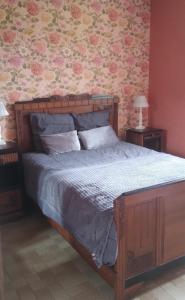 Gite La Bicyclette في Godewaersvelde: غرفة نوم بسرير مع اطار سرير خشبي