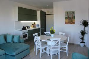 a living room with a table and chairs and a kitchen at Savana Modern Apartment by the sea in Golem